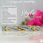 Front view of the Snapdragon Moon 4in1 Magnetic Bracelet, silver and gold coloured bracelet with snakeskin type designs, designed for pain relief, featuring various therapeutic elements. The bracelet is shown on a reflective surface with a pink flower behind it. 