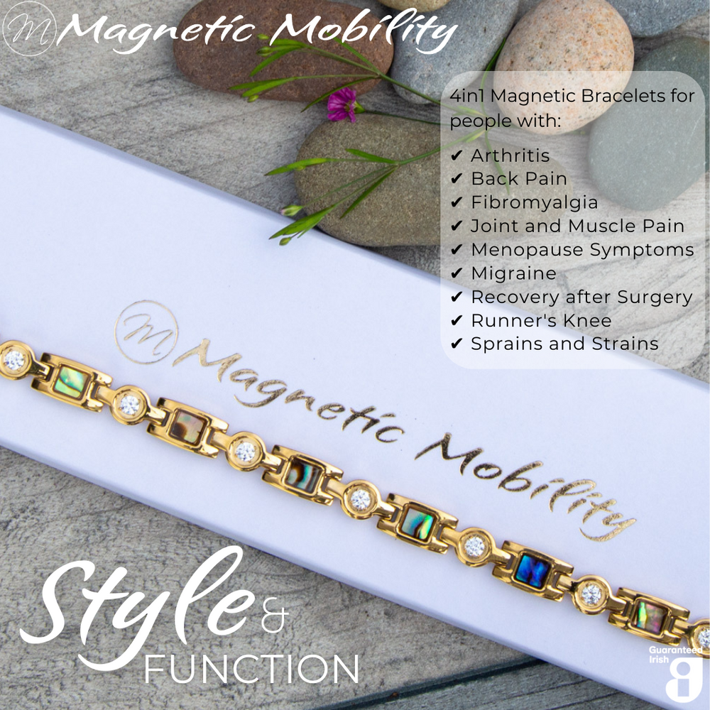 
                  
                    Load image into Gallery viewer, Top view of the Avens Sun 4in1 Magnetic bracelet from Magnetic Mobility on a gift box. Image shows the bracelet on a wooden surface with flowers and rocks. The iridescent designs of the gold stainless steel link magnetic bracelet are visible. The bracelet is designed for people with arthritis, back pain, fibromyalgia, joint and muscle pain, menopause symptoms, migraine and more.
                  
                