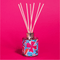 Reed diffuser with colorful design on a pink background