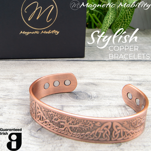 
                  
                    Load image into Gallery viewer, 45 degree view of the Buckthorn Copper Bracelet from Magentic Mobility. A celtic tree of life design features on the front of this copper bracelet and the strong neodynimum magnetis can be seen in the back of the open bangle. 
                  
                