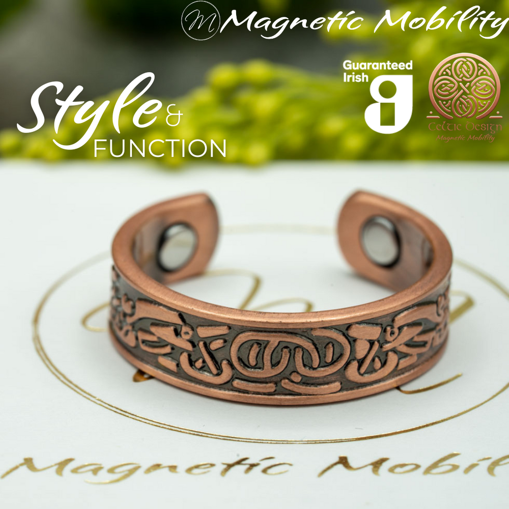 Clover copper ring by Magnetic Mobility featuring an intricate Irish design. Ring is shown on top of a white branded gift box. This adjustable ring is designed to be easily worn on arthritic fingers, providing both style and functionality.