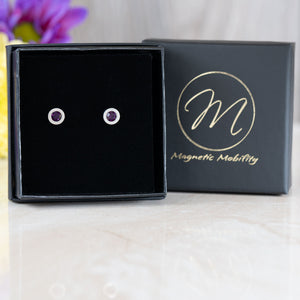 
                  
                    Load image into Gallery viewer, Birthstone Stud Earrings by Magnetic Mobility with purple Swarovski crystals, presented in an elegant black box. These magnetic back earrings offer fashionable pain relief and are showcased with Magnetic Mobility branding.
                  
                