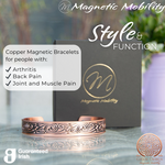 Front view of the Feverfew Copper bracelet from Magnetic Mobility. A copper bracelet with a Celtic design. Featuring 6 strong neodymium magnets. Perfect for people with arthritis and back pain. 99% pure copper. the image shows the bracelet in front of a black gift box and flowers. Part of the Celtic Collection from Magnetic Mobility.