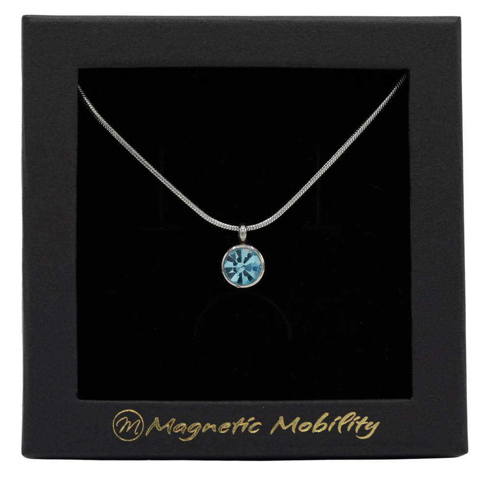 
                  
                    Load image into Gallery viewer, March Birthstone Necklace by Magnetic Mobility featuring a light blue Swarovski crystal pendant with a magnet. Perfect for neck pain relief, displayed in elegant black packaging.
                  
                