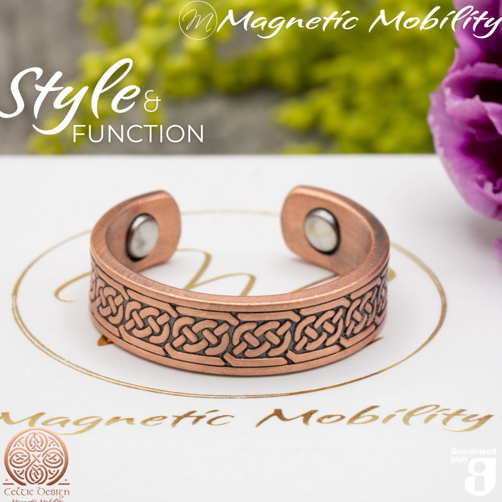 Privet copper ring by Magnetic Mobility featuring a Celtic knot design. Ring is shown on top of a white branded gift box. This adjustable ring is designed to be easily worn on arthritic fingers, providing both style and functionality.