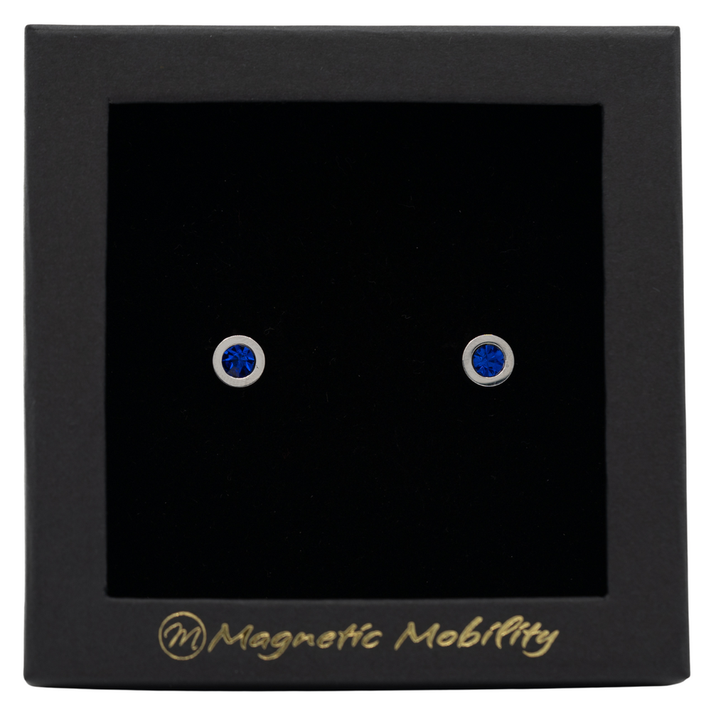 
                  
                    Load image into Gallery viewer, Magnetic Mobility September Birthstone Stud Earrings featuring saphire blue Swarovski crystals, elegantly presented in a black box with Magnetic Mobility branding. These magnetic back earrings offer stylish pain relief.
                  
                